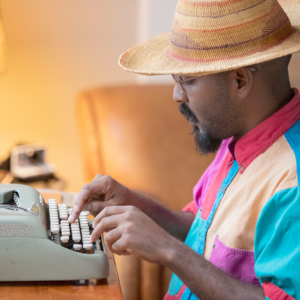 New Orleans poet, Cub the Poet, behind typewriter.